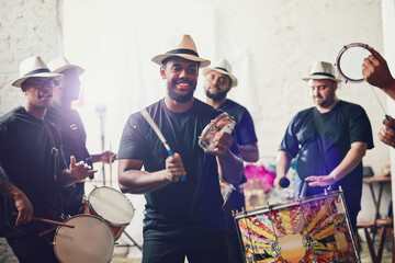 Their beats bring so much energy into the room. Shot of a group of musical performers playing drums together.