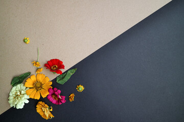 Beautiful flower flat lay arrangement on black and brown background. Flat lay bouquet, top view, overhead, empty space for copied text.