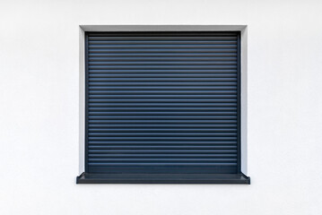 Large window in anthracite color with fully covered external blinds, view from the outside of the building.