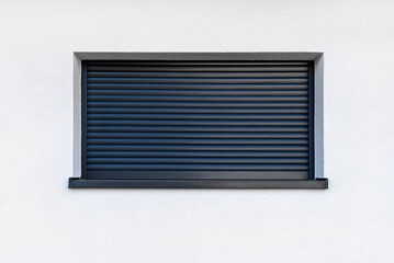 Large window in anthracite color with fully covered external blinds, view from the outside of the...