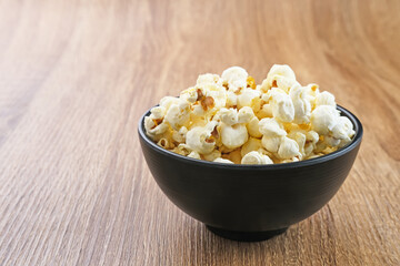 Popcorn, a kind of savory snack from corn seed. Served in a small bowl, selected focus.
