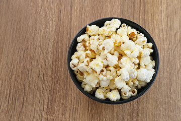 Popcorn, a kind of savory snack from corn seed. Served in a small bowl, selected focus.
