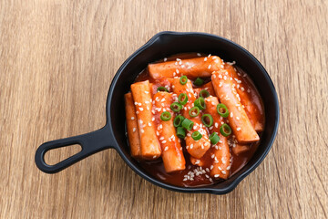 Tteokbokki or Topokki , stir fried rice cake stick, popular Korean street food with spicy gochujang sauce and sesame seed. 
