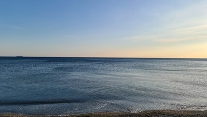 Savona, Italy - February 12, 2022: Panorama of the sea sunset, light above the water, ocean sunrise. Some little waves in winter days.
