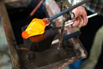 Glass blowing The hands of the craftsman working with molten glass Traditional crafts