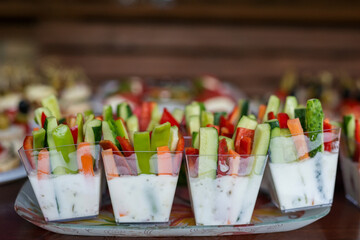 The buffet at the reception. Assortment of canapes on wooden board. Banquet service. Catering, snacks with different types of cheese and meat. Party Concept.