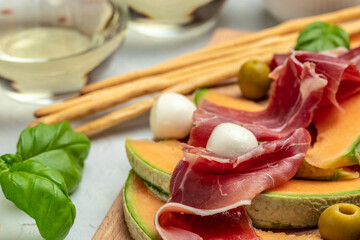 Fresh melon with prosciutto and basil. Antipasti, Traditional Spanish and Italian appetizer. Top view