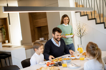 Young mother preparing breakfast for her family in the kitchen