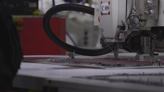 The machine sews products at the factory