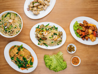 chinese seafood table Beancurd Kailan, Stir Fried yam, Xinghua Lor Mee, in a dish with chili sauce, and king's salad leaf top view on wooden background