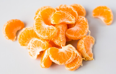 delicious peeled mandarin slices on white background