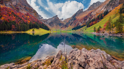 Beautiful autumn scenery. Amazing morning view of Swiss Alps. Santis peak reflected in the calm surface of pure water of lake. Unbelievable autumn scene of Seealpsee lake, Switzerland.