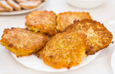 Potato pancakes with sour cream on white plate