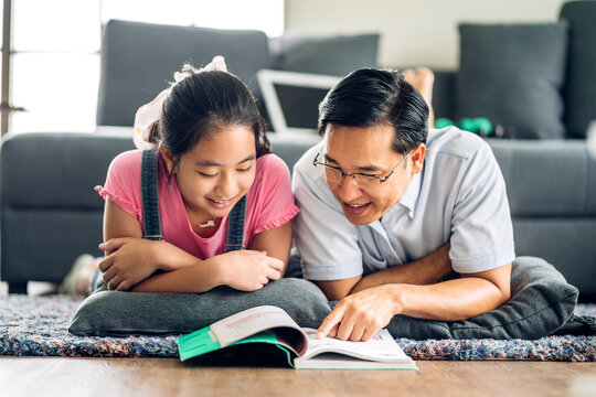 Portrait happy love asian family father teach little daughter asian girl learn and study on table.Dad and asian young girl writing with book and pencil making lessons in homeschool at home.Education