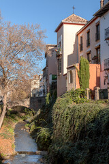 Fototapeta na wymiar The stone bridge and traditional moorish Spanish architecture around Darro River, Granada, Spain