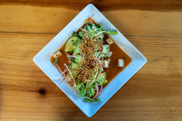Top down view of a plate of fresh Mexican aguachile with fish, avocado, cucumber