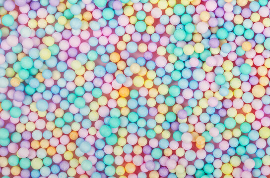Foam beads of various colors brightly colored background.