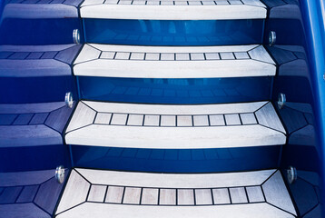 Upward-facing teak stairs on a luxury yacht. - obrazy, fototapety, plakaty