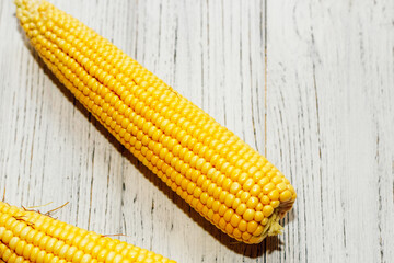 Sweet yellow corn lies on a wooden table.