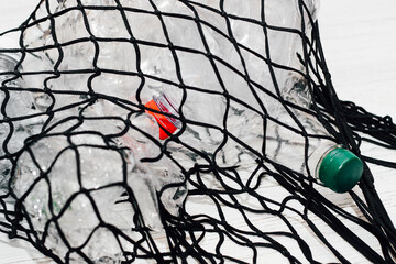 Black string bag with plastic bottles, ecology concept.