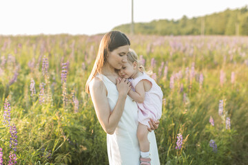 mother holds her child in her arms, nature, calm atmosphere - obrazy, fototapety, plakaty
