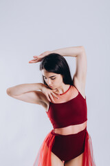 portrait of a beautiful ballerina in a red dress on a white background