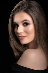 Fototapeta premium Portrait of a cute brunette. Black background. Swarthy complexion. Long hair