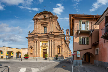 Fototapeta na wymiar Fossano, Cuneo, Italy - March 06, 2022: parish church of San Filippo (18th century) in piazza Aldo Nicolaj with the arcade and the buildings of the historic center