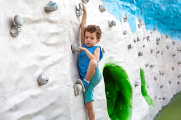 Caucasian boy climbing up a climbing wall