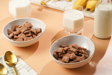 Nougat bites - sweet cocoa and hazelnut wheat puffed pillows - breakfast cereal in white bowls,...