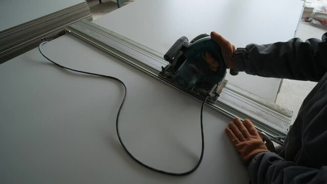 Male hands measuring and cutting gypsum plasterboard
