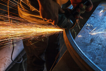 Flex metalworking. Worker cuts metal at a construction site - obrazy, fototapety, plakaty