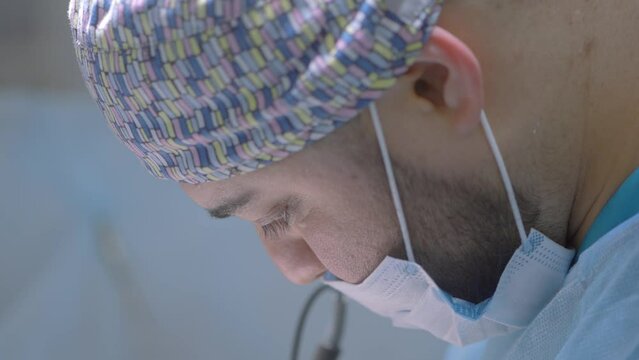 Close up of surgeon in a special uniform performing medical procedure. Action. Concept of healthcare and medicine.