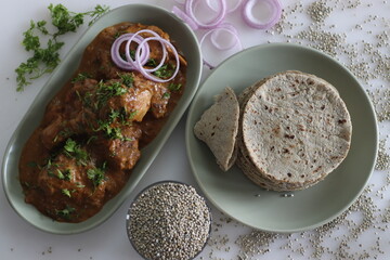 Soft flat bread made of pearl millet flour. Served with chicken in cashew gravy garnished with fresh coriander leaves