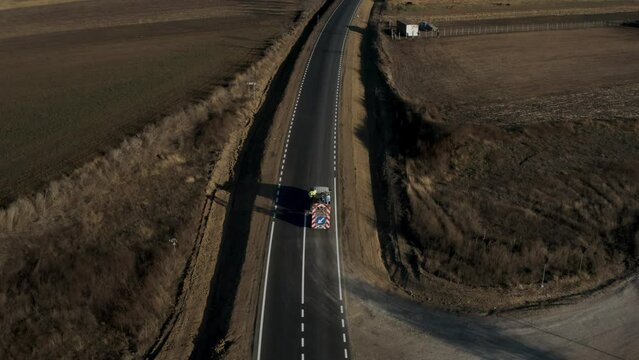 Road workers use hot-melt scribing machines to paint trafic signs on asphalt road surface outside the city. Road marking. Workers and paint sprayers for roads. Thermoplastic paint for road marking.