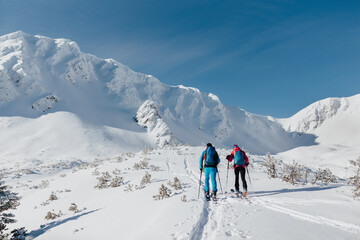 Rear view of ski touring couple hiking up a mountain in the Low Tatras in Slovakia.