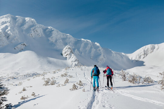Rear view of ski touring couple hiking up a mountain in the Low Tatras in Slovakia.