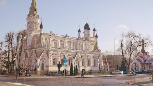 Pokrovsky Cathedral. Action. A huge beautiful red stone church with long golden domes standing on a crossroads where many people go about their business.