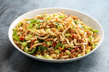 Pork, peanut udon noodles with pak choi, mangetout and red chili. Asian food