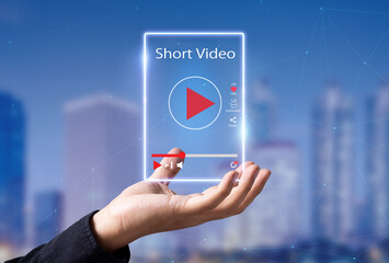 Short Video marketing concept.Man hands holding virtual short video player with blurred city as...