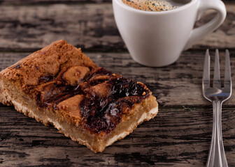 cup of coffee with cake on white plate  on wooden table in cafe