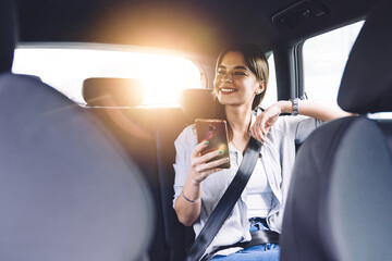 Smiling young woman with smartphone in car © BullRun