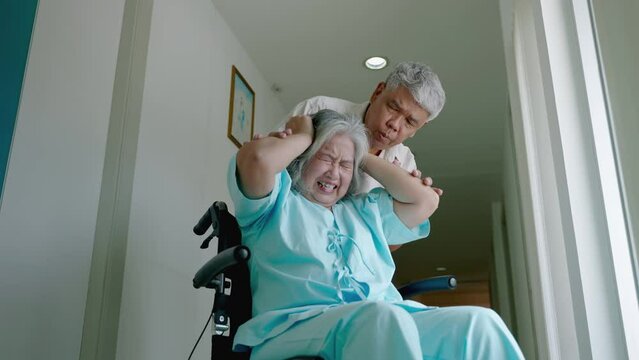 elderly woman with psychiatric symptoms is in a wheelchair with an elderly couple caring for her within a psychiatric hospital. concept of health problems
