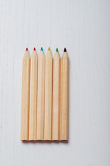 Wooden colored crayons on a white background.