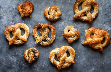 Top down view of an assortment of homemade baked pretzels with various toppings.
