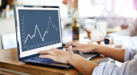 Young asian business woman sitting at table in cafe and working with stock trading on laptop computer, Close-up image