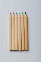 Wooden colored crayons on a white background.