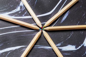 Wooden colored crayons on a dark background.