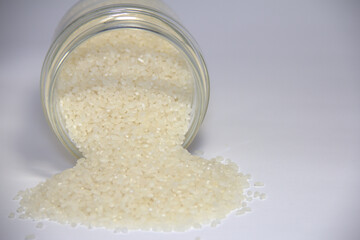 White rice poured from a transparent jar. 