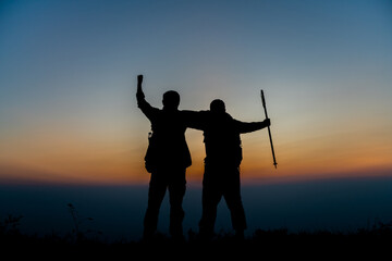 silhouette of backpackers standing in pairs on the mountain successful concept scene